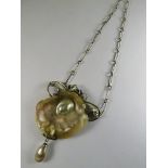 Circa 1910 an art nouveau white metal necklace with a mother of pearl, shell and "pearl", natural