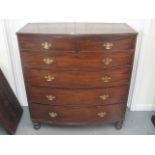 A bow fronted Georgian chest of two short and four graduated long drawers on turned feet