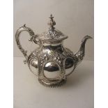 A Victorian silver Hall and Co Silversmiths, Manchester teapot having ornate repousse decoration,