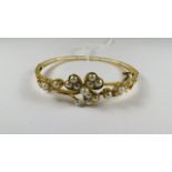 A Victorian yellow gold hinged bangle set with seed pearls in a clover motif, original fitted case