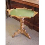 A gilt show wood table having green painted top over ornate carved column and splayed legs