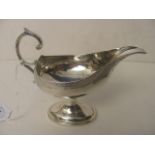 A George III silver sauce boat with engraved border on an oval base, London 1795, 4" high