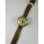 W of S 9ct gold cased ladies wrist watch with silvered dial, having gold coloured buttons and hands,