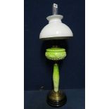 A 19th century green pressed glass oil lamp with gilt highlights over a painted glass column on a