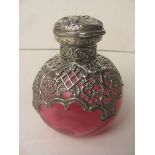 A Victorian silver topped rose water bottle with repousse lid and pierced neck over a cranberry