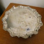 A silver salver on raised feet