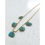 A yellow gold necklace set with five turquoise beads on a rope twist chain