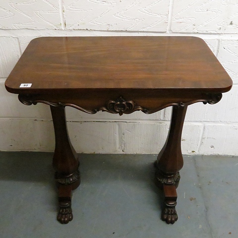 A small Victorian mahogany side table with carved frieze supported on two inverted baluster and