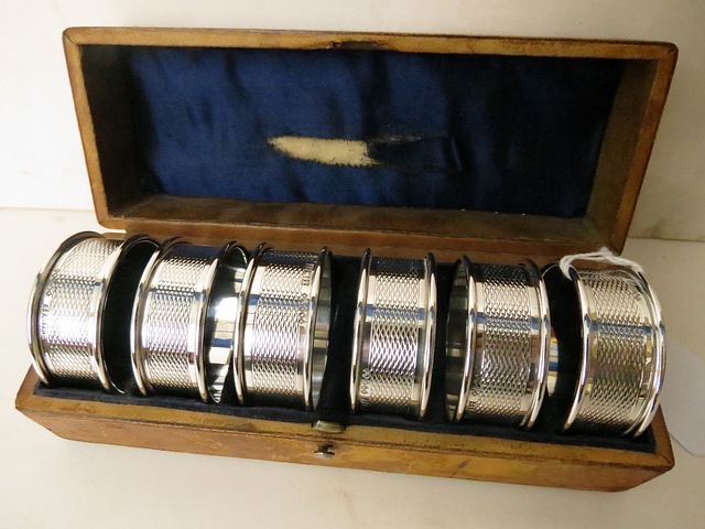 A leather cased set of six Birmingham silver engine turned napkin rings