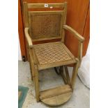 An early 20th century J Mole of High Wycombe oak and cane wheel chair