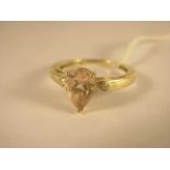 A yellow gold pear cut morganite and diamond three stone ring