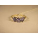 A yellow gold Tanzanite trapeze cut ring, over 1.80cts total