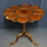 A George 111 mahogany oyster top tea table having a carved and shaped top over a turned column and