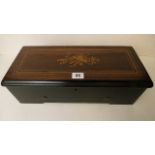 A small early 20th century musical box with a marquetry inlaid lid and playing six airs