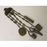 A 19th century pressed brass chatelaine with accessories