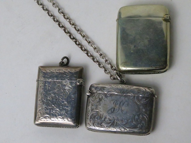 A late Victorian silver vesta case on chain, Birmingham 1900, an Edwardian silver vesta case,