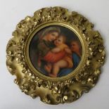 An early 20th century German porcelain plaque of circular form depicting a woman and two children in