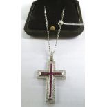 An 18ct white gold Cartier style ruby and brilliant cut diamond cross on a white gold chain