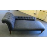 A late 19th century blue upholstered chaise on turned legs