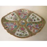 A 19th century Canton footed dish of shaped oval form, decorated with reserves and central medallion