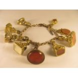 A 9ct gold bracelet set with a collection of 19th century pinchbeck fobs, one in the form of a dog