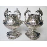 A pair of turn of the century Goldsmiths and Silversmiths Company silver vases with ornate handles