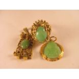 A 14ct yellow gold jade set ring, together with two gold pendants, also set with jade