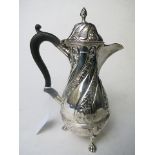 A Birmingham silver hot milk jug having ornate embossed decoration