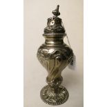 A Victorian rococo style silver sugar caster with ornate raised decoration on a pierced circular