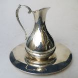 A continental white metal communion jug and stand, marked 900