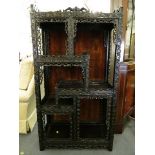 A late 19th century oriental rosewood ornate carved display stand having a raised, pierced back over