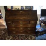 A Georgian mahogany bureau, the fall flap enclosing central cupboard flanked by pigeonholes and