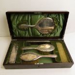 An early 20th century mahogany cased silver backed dressing table set