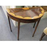 An Edwardian demi lune inlaid fold over card table having green baize and standing on square