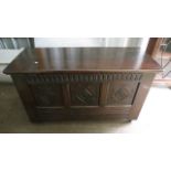 An oak blanket box with three carved panel front, on castors, 26 3/4 x 47 1/2 x 18 7/8