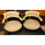 A pair of Victorian upholstered tub chairs in the aesthetic style, with ebonized and gilded