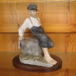 A large Royal Copenhagen porcelain figure of a fisherman on a rock, 13 high