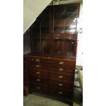 A 19th century mahogany display secretaire bookcase over a fitted drawer, lower drawers, inlaid