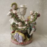 A 19th century French porcelain figure group, 18th century style figures around a golden urn, having