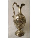 A Victorian silver ewer having embossed decoration on a raised circular base, marked rubbed