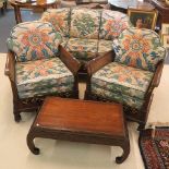 A 1920s Bergere suite comprising two armchairs and a sofa with gilt highlights to the carved arms