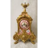 A 19th century French gilt mantle clock having ornate cast decoration with pink glazed foliate