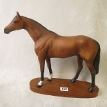 A large mat glazed figure of a brown horse on a wooden base entitled Racehorse, 12 high