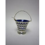 A George V silver pedestal Sugar Bowl, pierced and engraved with swing handle, blue glass liner,