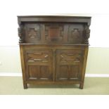 An oak Court Cupboard with moulded geometric panels fitted two cupboard doors above and two below,