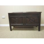 A 17th Century oak Coffer with panelled top and carved two panelled front, 3ft 9in W