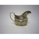 A George III Irish silver Milk Jug of shaped oval form engraved initials within circular