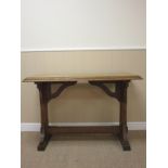 An Aesthetic Movement oak Centre Table with carved edge on cheval frame with chamfered stretcher,