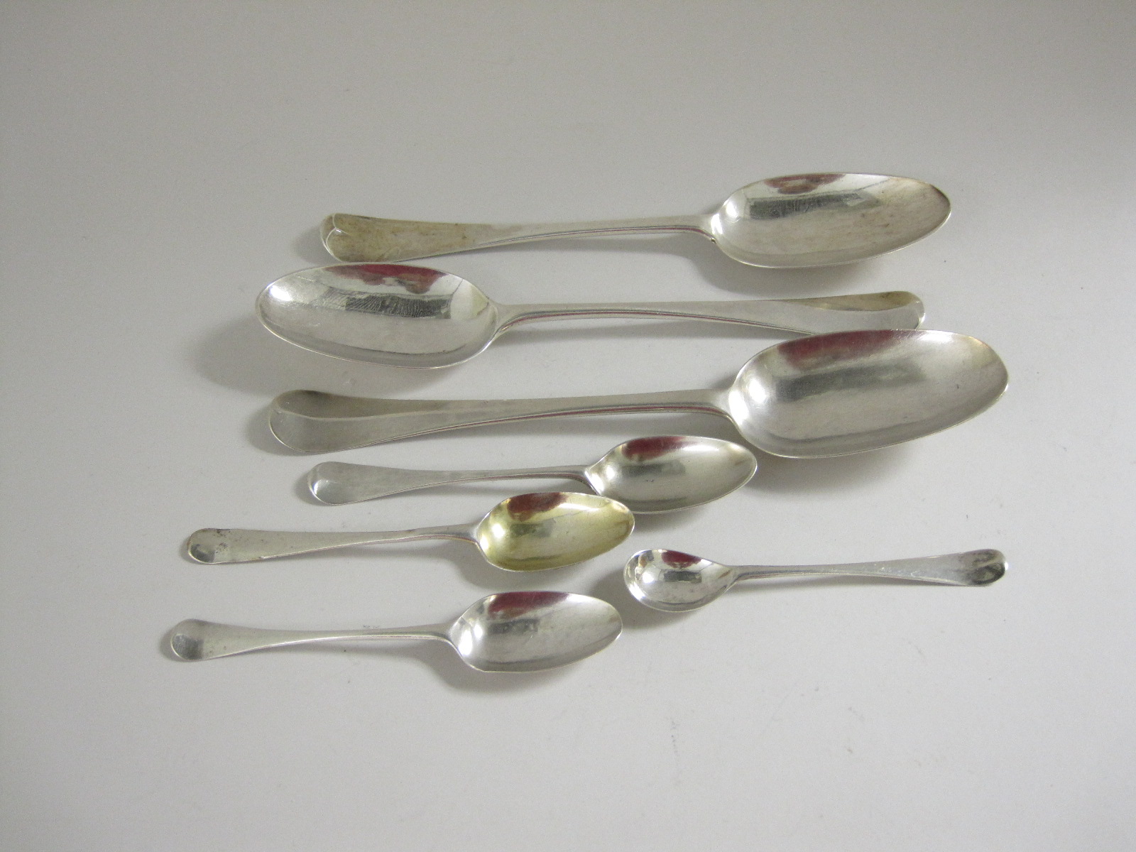 Three 18th Century silver bottom marked Table Spoons hanoverian pattern with pattern backs, and four