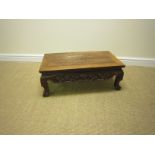 A Chinese hardwood low Occasional Table with shaped and scroll carved frieze on dwarf cabriole